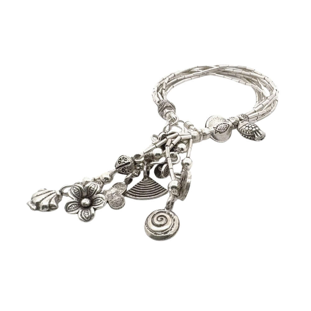 Silver bracelet with various charms on a white background