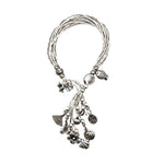Silver bracelet with various charms on a white background