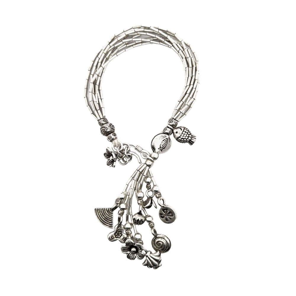 Silver bracelet with various charms on a white background