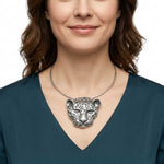 Woman wearing a silver necklace with a Taxco silver jaguar pendant on a white background