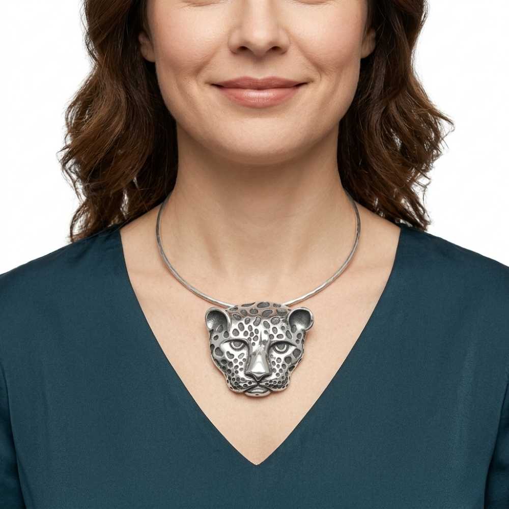 Woman wearing a silver necklace with a Taxco silver jaguar pendant on a white background