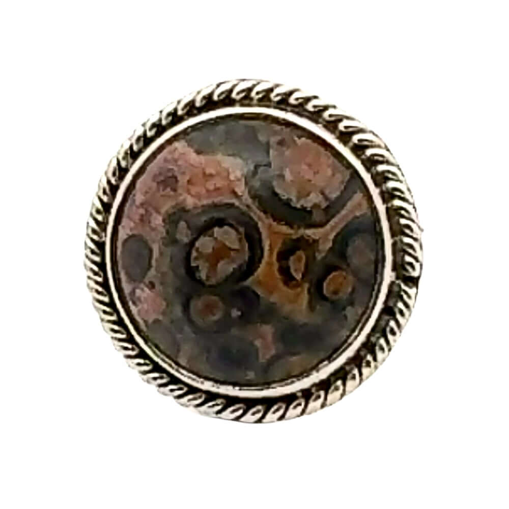 Round stone with decorative silver frame on a white background