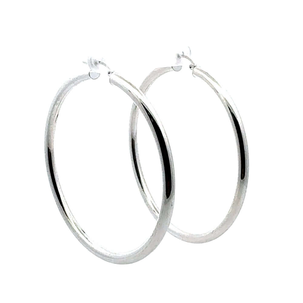 Pair of 6.5 cm silver hoop earrings on a white background
