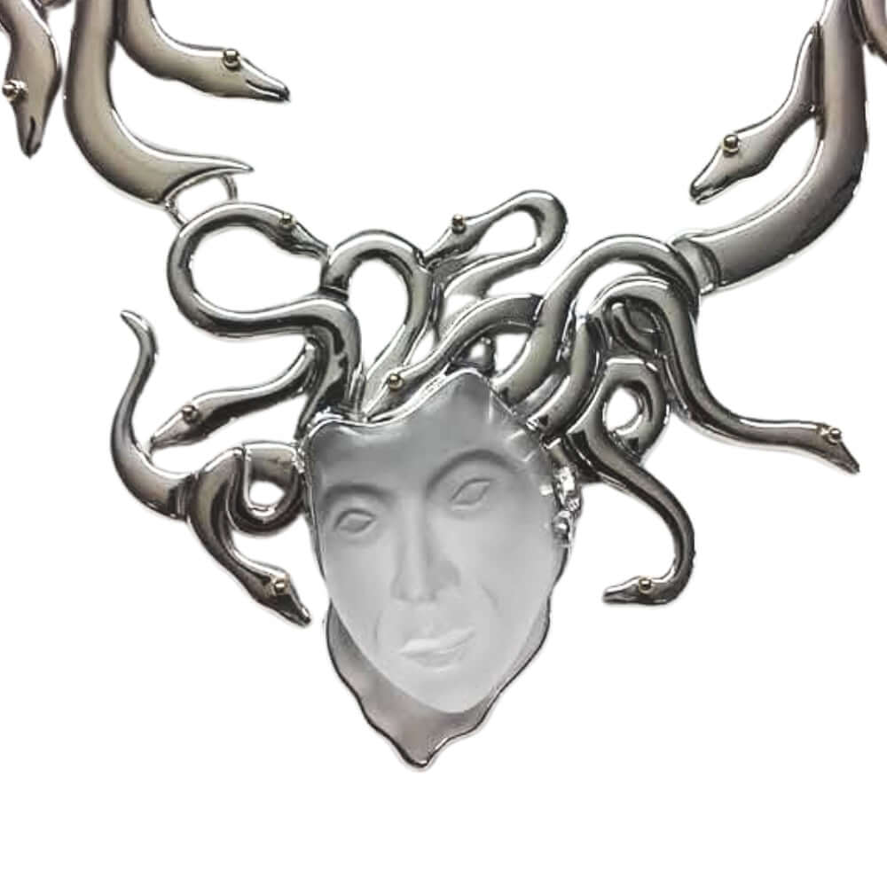 Silver necklace with a face design and snake-like branches on a white background
