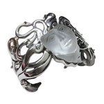 Silver cuff bracelet with a face-shaped stone on a white background