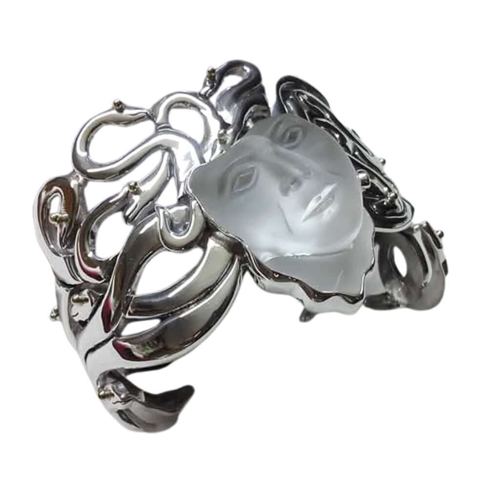 Silver cuff bracelet with a face-shaped stone on a white background