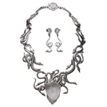 Silver necklace and earrings set on a white background