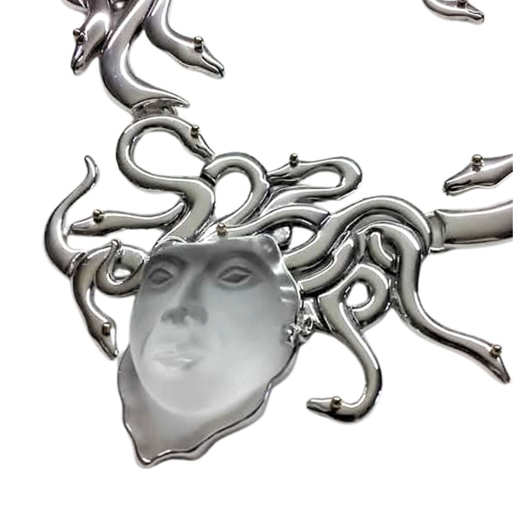 Silver necklace with a face pendant on a white background