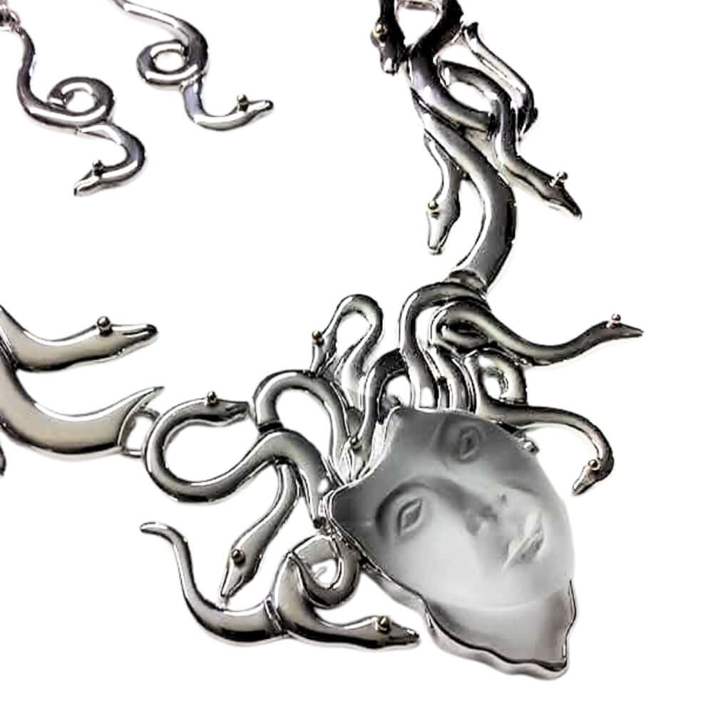 Silver necklace with a face pendant on a white background