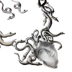 Silver necklace with a face pendant on a white background
