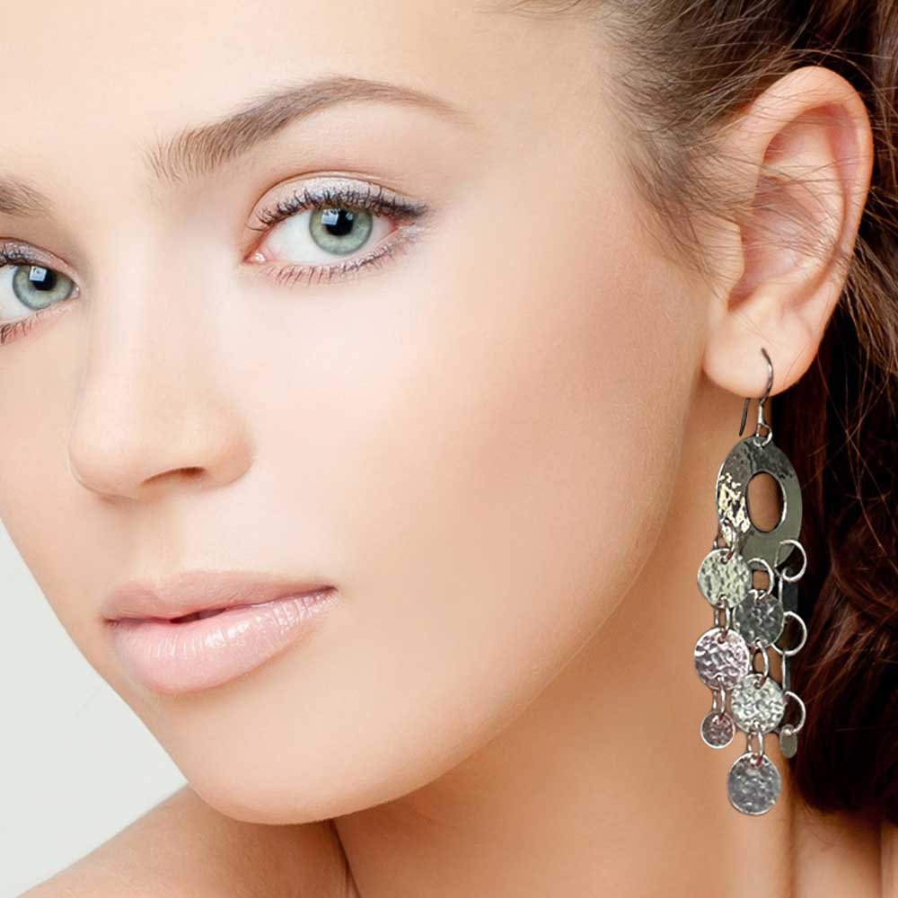 Close-up of a woman wearing a silver earring with multiple circles.