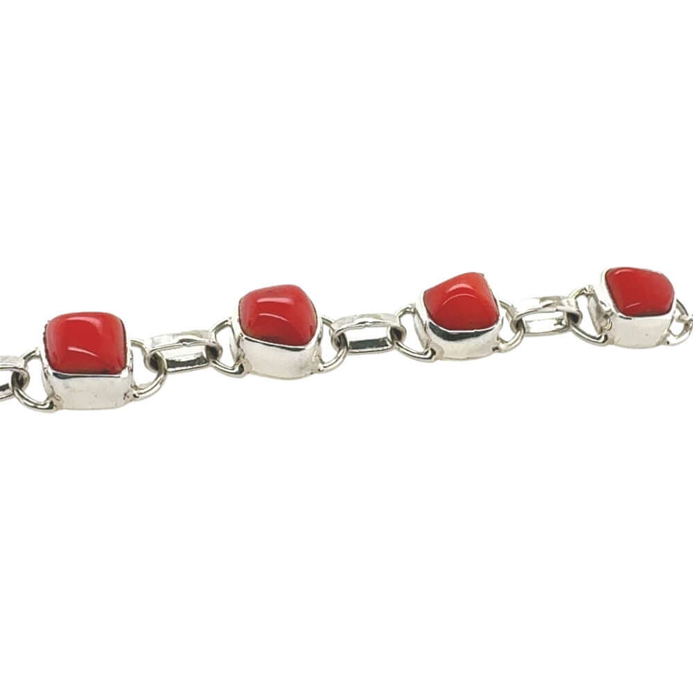 Silver bracelet with red coral on a white background