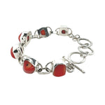 Silver bracelet with red coral on a white background