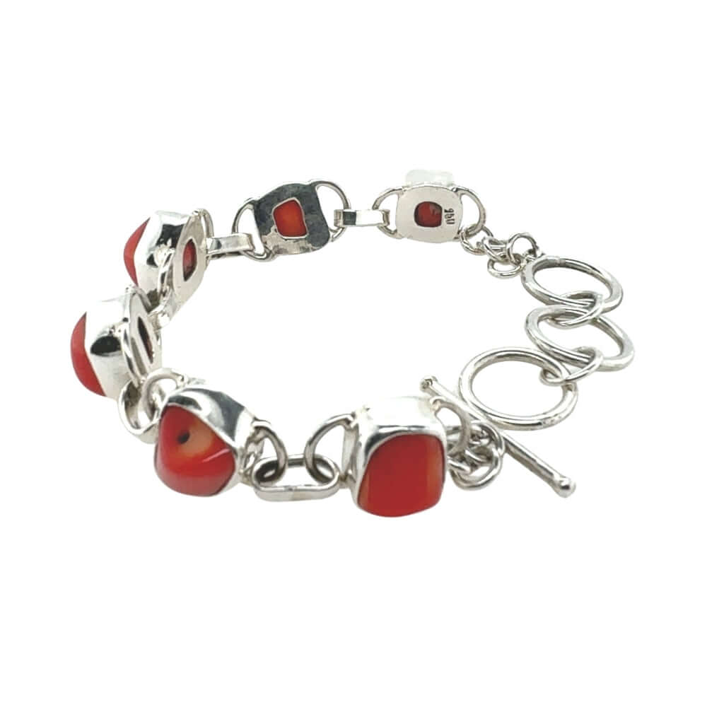Silver bracelet with red coral on a white background