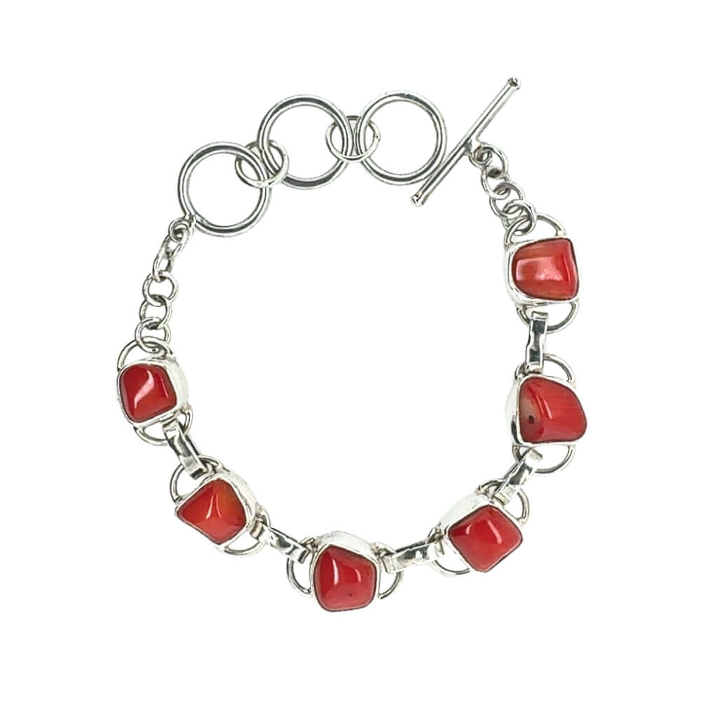 Silver bracelet with red coral on a white background