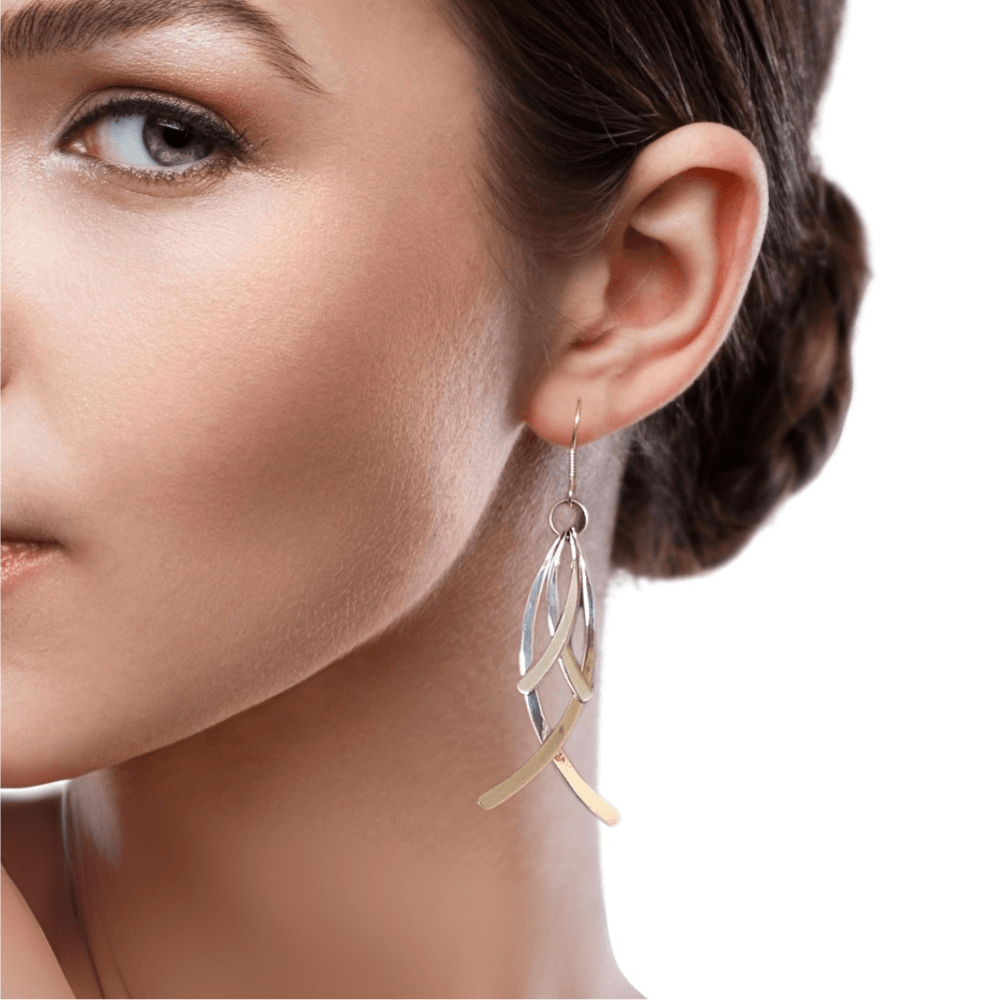 Close-up of a woman wearing silver earrings with a white background