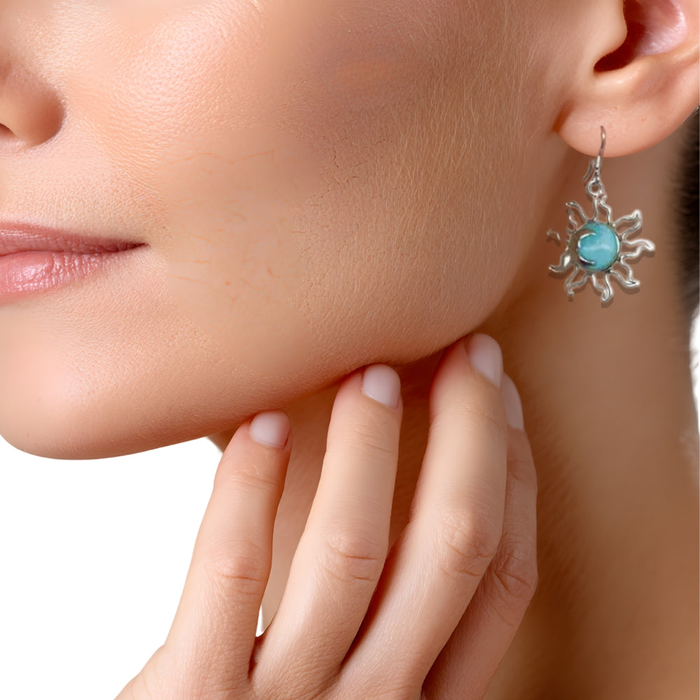 Close-up of a woman wearing a silver earring with a turquoise stone.