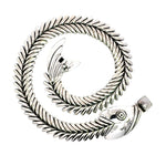 The articulated sterling silver fishbone necklace coiled into a spiral, showcasing the design details of the fish head and tail on a clean white background.