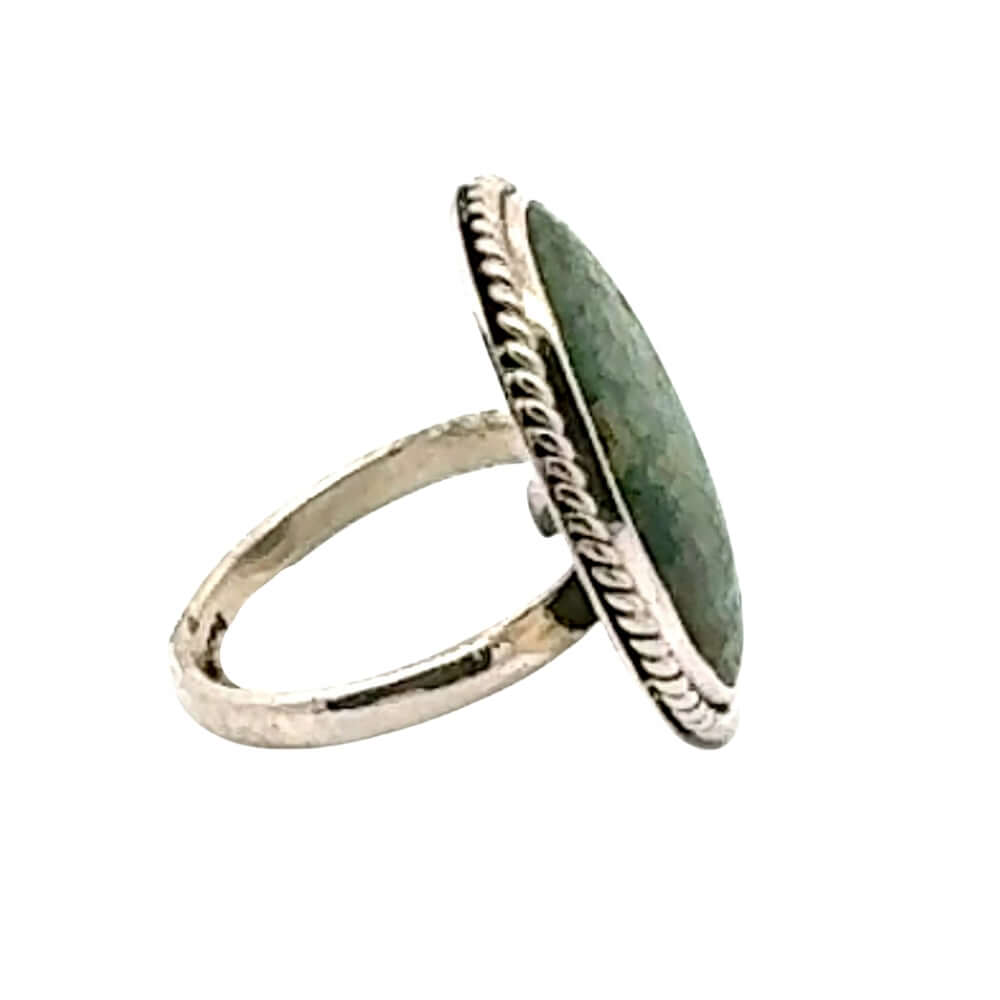 Silver ring with a green stone on a white background
