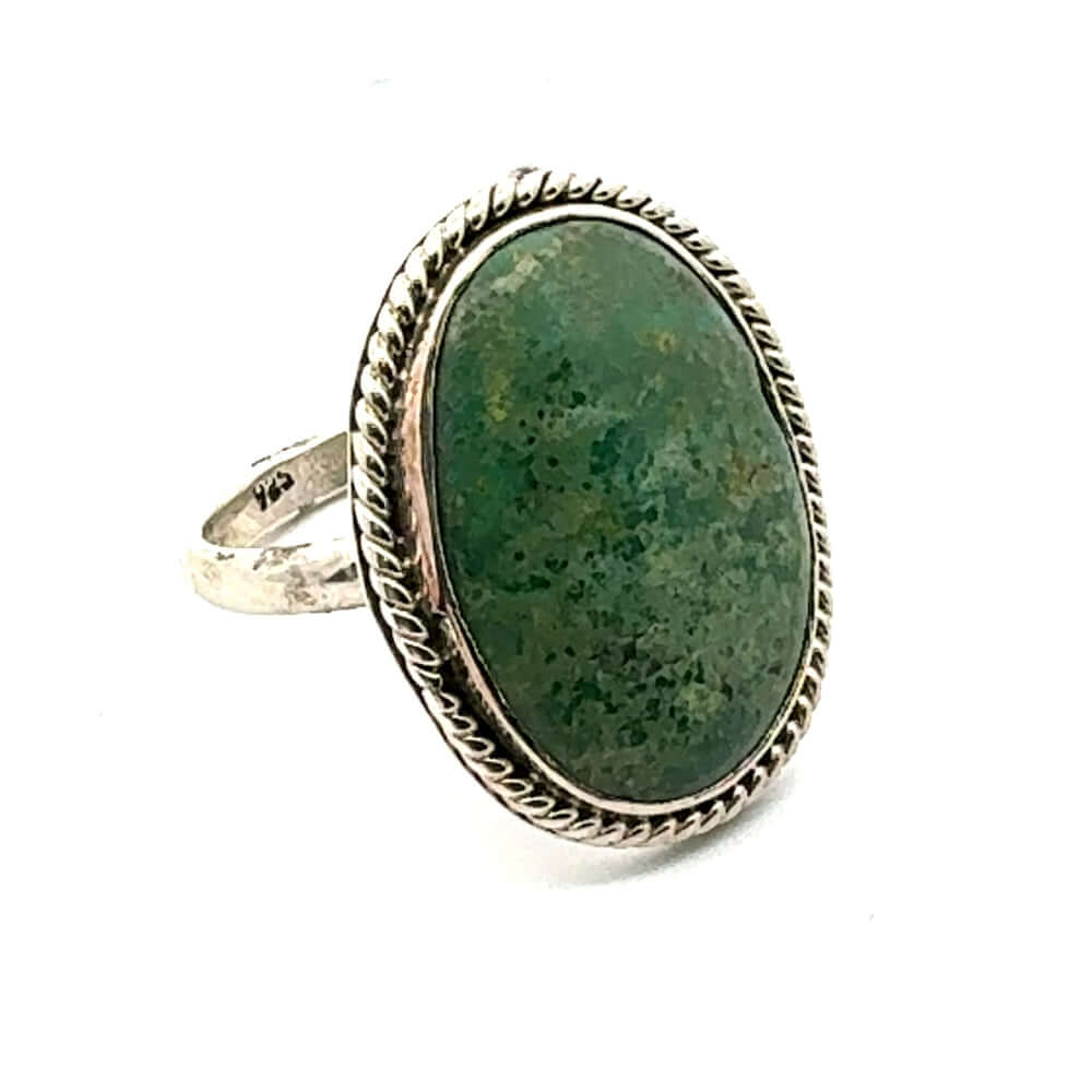 Ring with green stone and silver band on a white background
