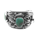 Front view of a wide handmade 925 sterling silver cuff bracelet featuring three green turquoise stones and detailed silver leaves.