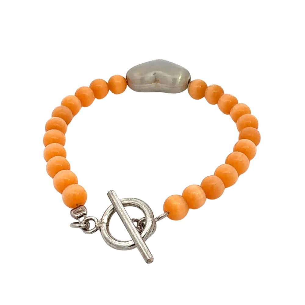 Orange cats eye beaded bracelet with a silver clasp on a white background