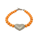 Bracelet with orange cats eye beads and a silver heart-shaped clasp on a white background
