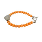 Orange cats eye beaded bracelet with silver heart on a white background