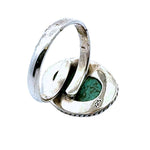 Silver ring with a green stone on a white background