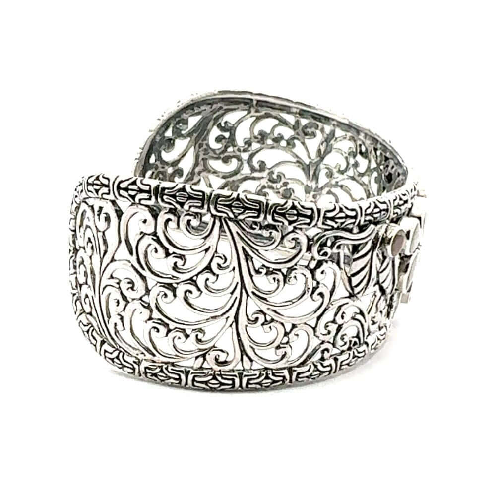 Silver bracelet with intricate filigree design on a white background