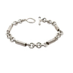 Silver bracelet with coil design and rings in white background