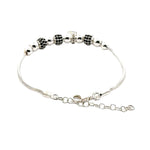 Silver bracelet with black and silver beads on a white background