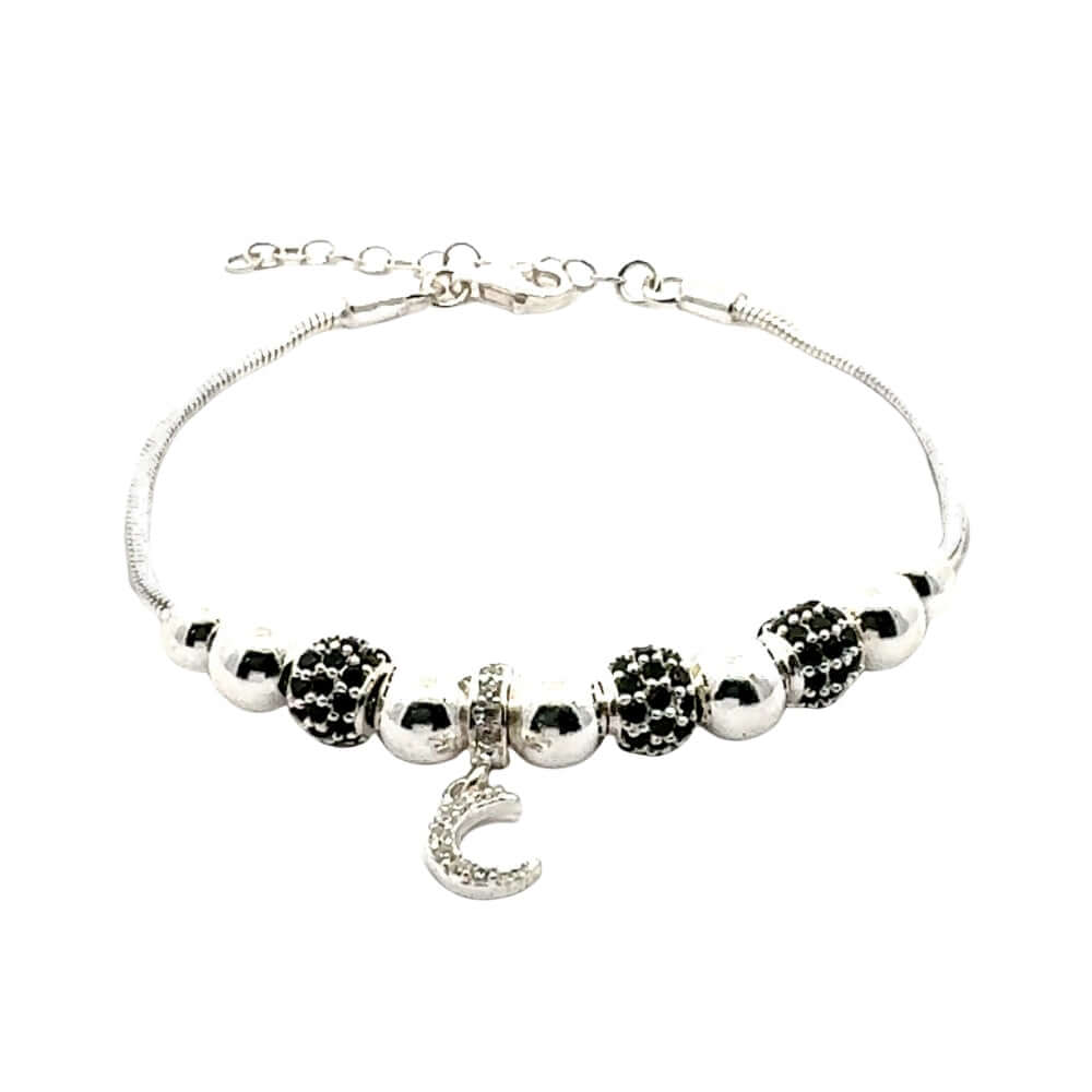 Silver bracelet with black and white beads and a heart charm on a white background