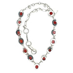 Silver necklace with red coral from the back on a white background