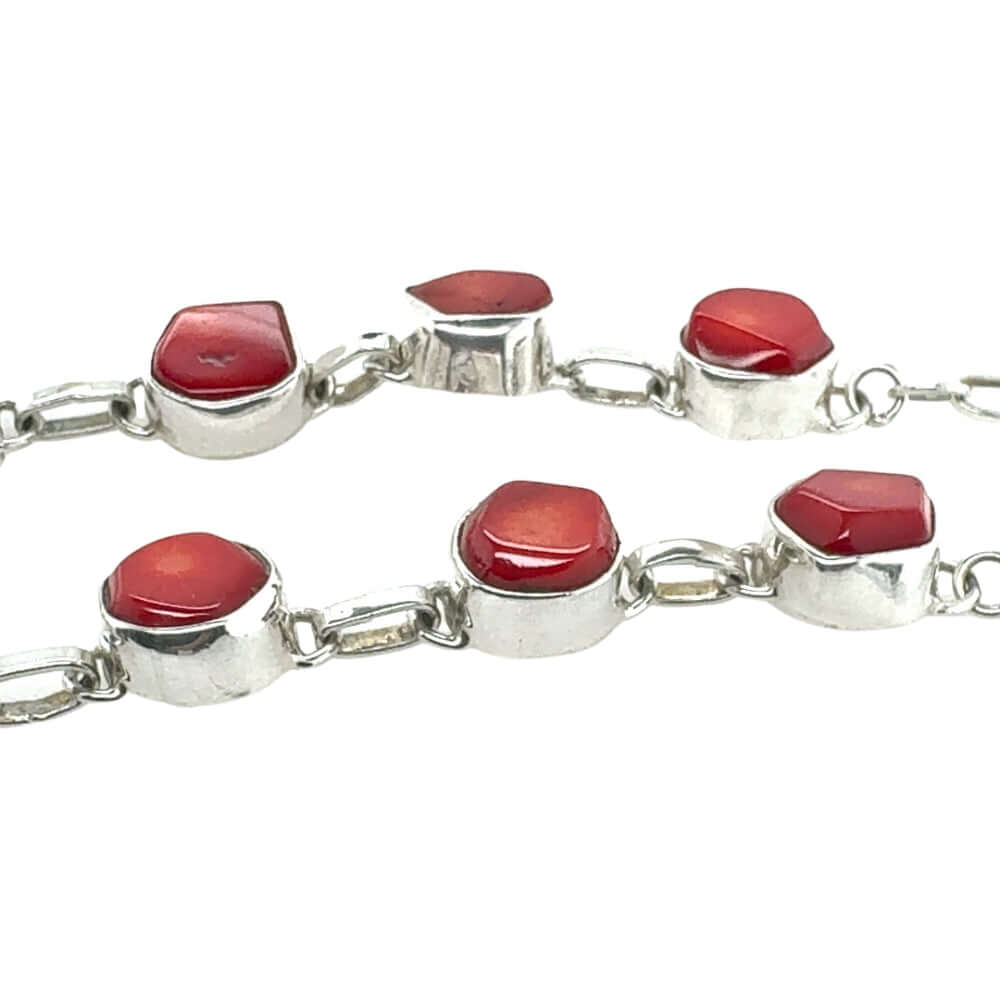 Silver necklace with red coral on a white background