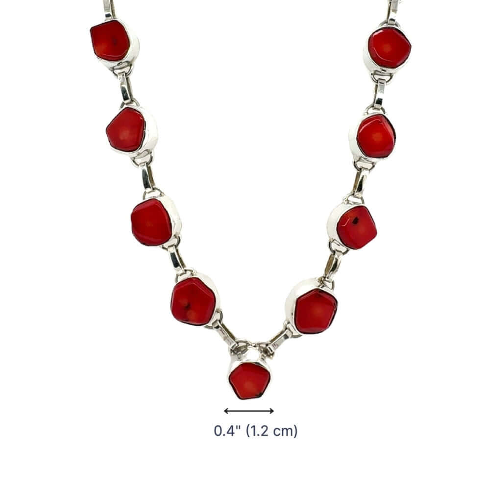 Necklace with red coral and silver links on a white background