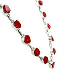 Necklace with red coral and silver links on a white background