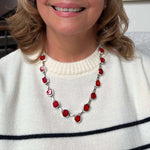 Person wearing a red coral silver necklace with a white sweater
