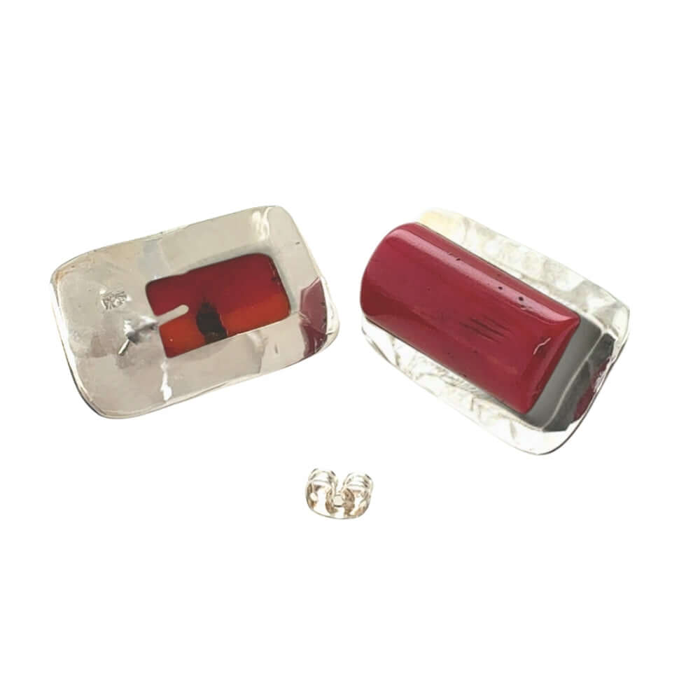 Pair of earrings with red coral and silver design on a white background