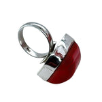 Silver ring with a red coral on a white background