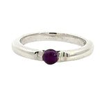 Silver ring with a purple gemstone on a white background