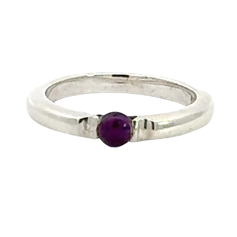 Silver ring with a purple gemstone on a white background