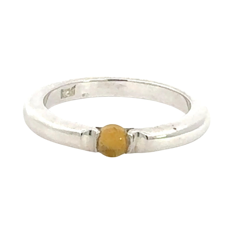 Silver ring with a yellow stone on a white background