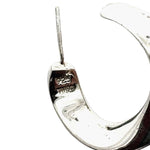 Close-up of a silver hoop with stamps on a white background