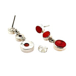 Silver earrings with red coral on a white background