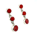 Silver earrings with red coral on a white background