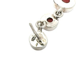 Silver earrings with red coral on a white background showing stamp