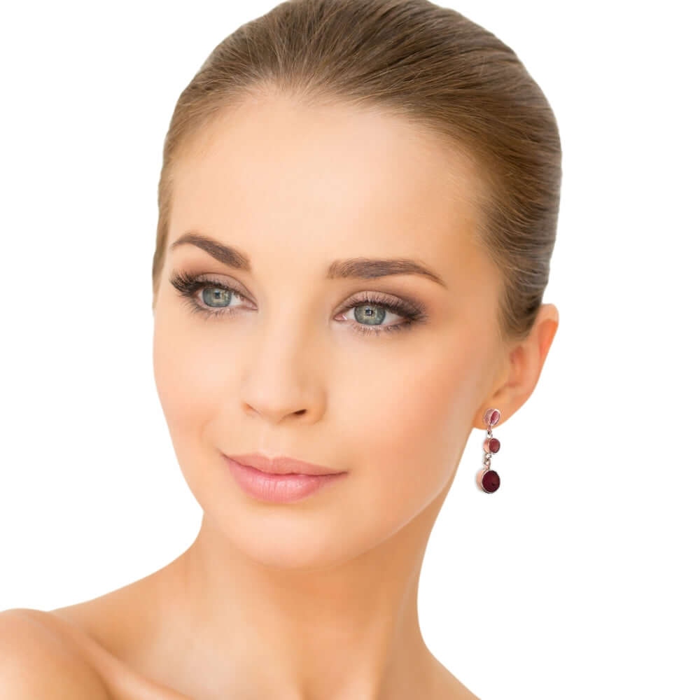 Close-up of a woman wearing silver coral earrings on a white background