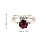 Silver ring with a pink gemstone and measurements on a white background