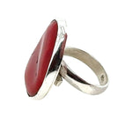 Silver ring with a red coral on a white background